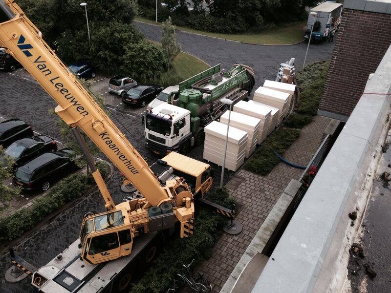 Kraan hijst materiaal op het dak