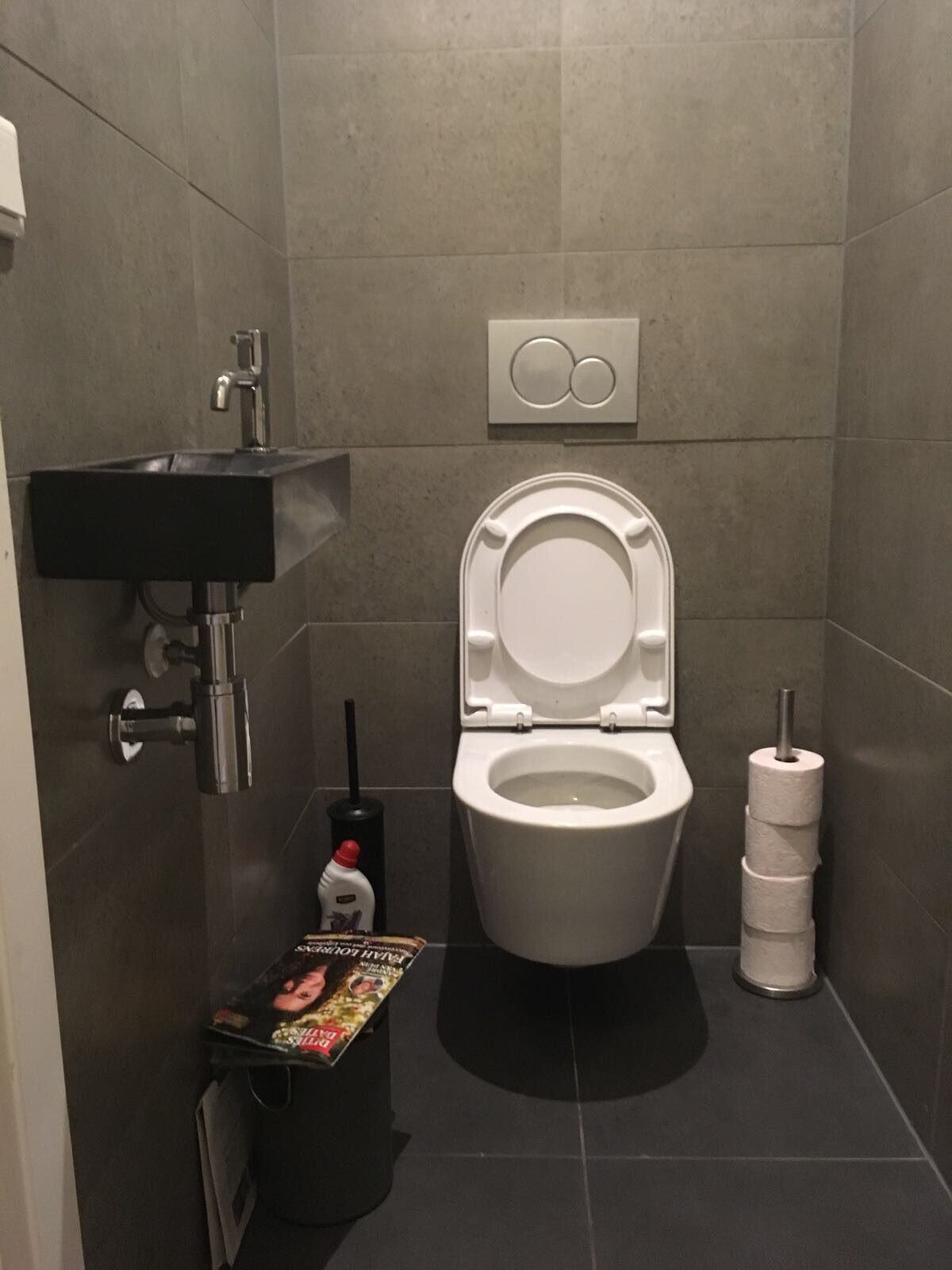 Zwevend toilet met donkere tegels
